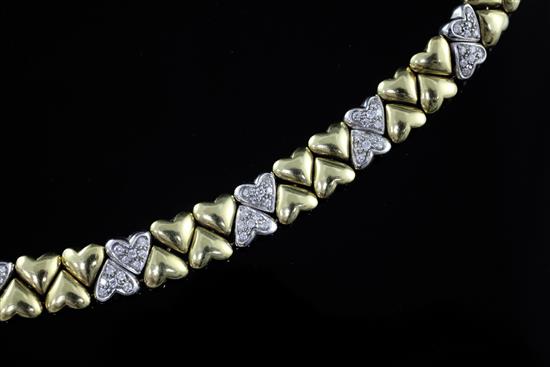 A modern two colour 18ct gold and diamond set double row heart shaped link bracelet, 18.3cm.